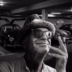 Schwarzweiß-Porträt von MaiP Jorgenson mit Sonnenbrille vor klassischen Automobilen. Das Cover des Songs „Parkplatz der Erinnerung“ steht für Nostalgie, vergangene Zeiten und persönliche Erinnerungen.